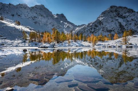 Bergsee mit Lärchenwald im Herbst
