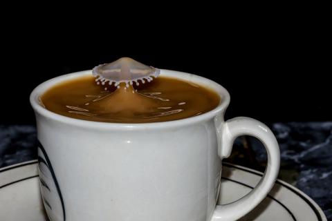 Tasse Kaffee mit Haube Milch