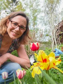 Frau im Garten mit Tulpen und Katze 