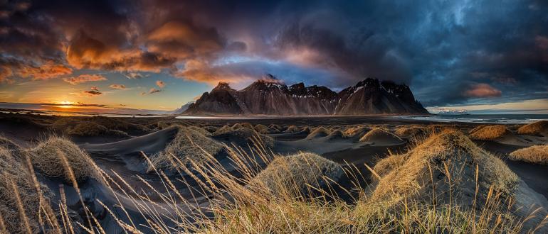 IDEE: Die auch Batman-Mountains genannte Bergkette in Island wird geschickt mit den schwarzen Lavasand-Dünen verbunden.
GESTALTUNG: Vor allem die Perspektive dicht über die Hügel hinweg macht den Reiz des Fotos aus und verbindet die Zwei-Meter-Dünen mit der Bergkette im Hintergrund. Sehr gut die leicht vom Wind unscharf gemachten Gräser im Vordergrund. Das halbe Gegenlicht arbeitet die Dünen sehr gut heraus. TECHNIK: HDR-Panorama aus insgesamt drei
mal 15 Aufnahmen, fotografiert mit Stativ und von einem kleinen Dünenhügel aus. 