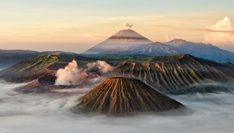 IDEE: Die einzigartige Kraterlandschaft auf Java im Morgenlicht. Rauch und Nebel hüllen die Landschaft ein. Der Bromo (links) und der Semero (hinten) stoßen Rauchwolken aus. Im Tal ist der Morgennebel zu sehen.
GESTALTUNG: Das Seitenlicht der aufgehenden Sonne modelliert die Flanken der Vulkane. TECHNIK: Nächtlicher Aufstieg und frühmorgens
vom Stativ aus fotografiert.