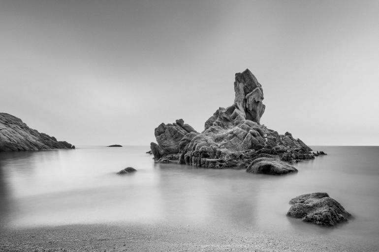 IDEE: Die eigentlich eher unspektakulären Felsen werden durch die konsequente Weichzeichnung von Himmel und Wasser in Szene
gesetzt. Fotografiert an der Costa Brava. GESTALTUNG: Ein Bildaufbau wie aus dem Lehrbuch. Der große Felsen im goldenen Schnitt ist der zentrale Anlaufpunkt für den Blick, der zunächst zum kleinen Felsen nach
vorn, dann nach hinten links gelenkt wird. TECHNIK: Die Langzeitbelichtung macht nicht nur das Meer weich, sondern softet auch
noch die letzten Strukturen im Himmel ab. Einsatz eines Dreifach-Neutraldichtefilters. 