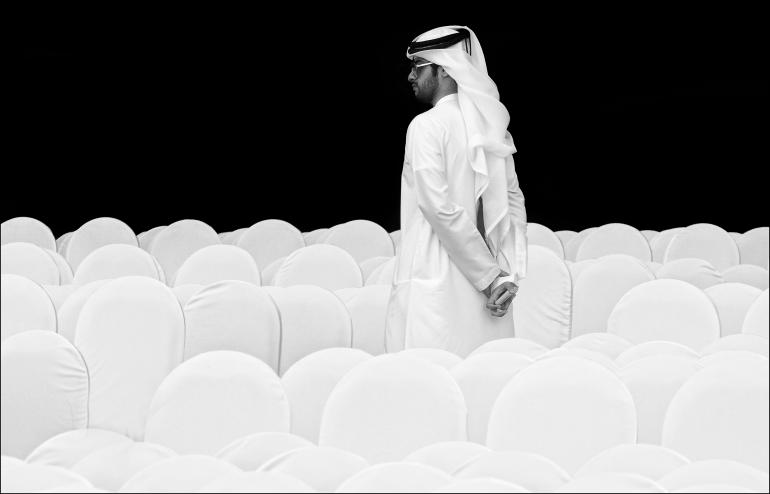 IDEE: Ein in sein traditionelles Gewand gekleideter Veranstaltungsbesucher in einer Halle in Dubai. Er bildet mit seiner Kandora ein sehr leicht wirkendes Ensemble mit den mit Hussen überzogenen Stuhlreihen.
GESTALTUNG: Gut herausgearbeitete Formen. Überzeugt vor allem durch die Weißtöne vor dem satten Schwarz des Hintergrunds. TECHNIl: Zufällig bei den Hipa-Awards vor der Preisverleihung gesehen und aus der Hand
heraus mit Hallenbeleuchtung fotografiert. Leichte Belichtungskorrektur nach oben. 
