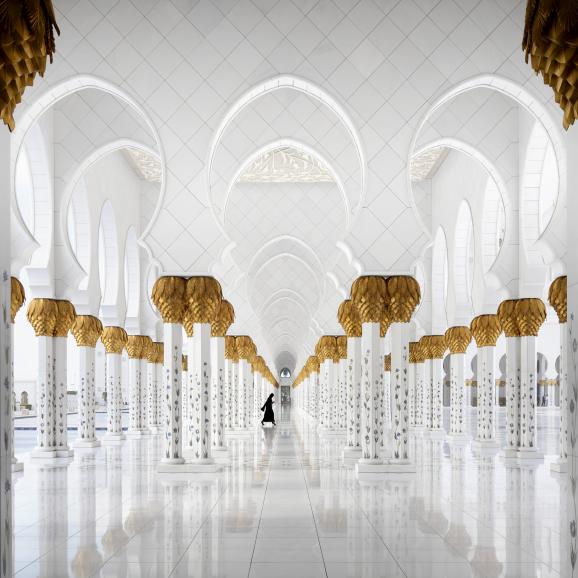 Platz 2 &quot;Moscheebesucherin&quot; – IDEE: Die Sheik-Zayed-Moschee in Abu Dhabi bietet nicht nur über 40.000 Gläubigen Platz, sondern
wurde auch mit verschiedenen Marmorsorten und sehr viel Blattgold bestückt. Der Fotograf hatte Glück: Eine...
