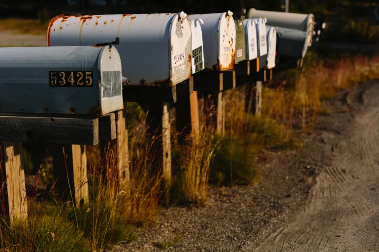 Briefkästen am Straßenrand schimmern in der Morgensonne. Die atmosphärische Aufnahme entstand auf der Kenai-Halbinsel.