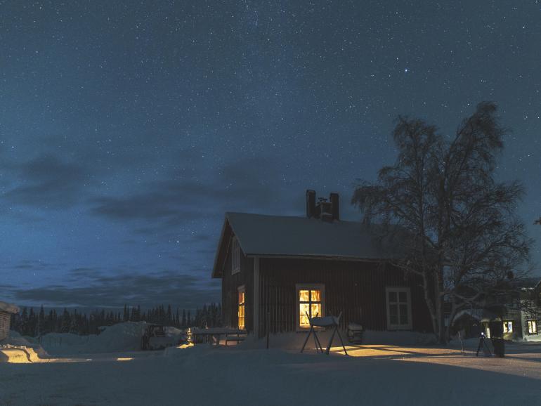 Winterromantik pur: Die Petroleumlampe in der Küche der Blockhütte im Wildnisdorf Solberget bringt Licht in die sternenklare Nacht.