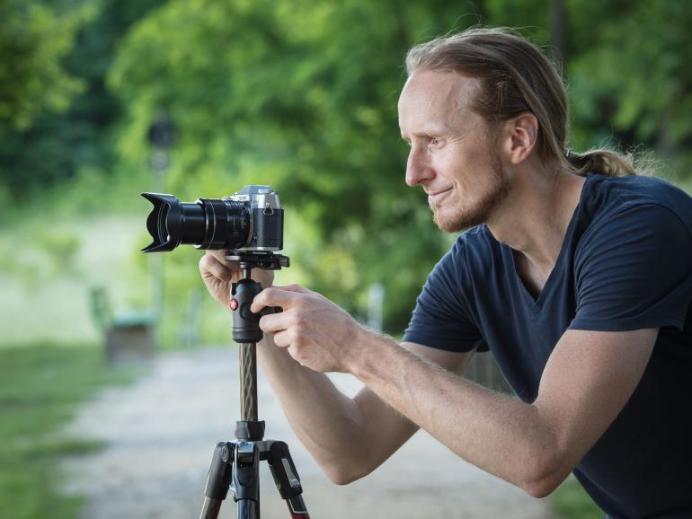 Fotograf Michael Breitung bei der Arbeit. Hier hat er seine Systemkamera auf der Carbon-Versionen des Befree Advanced Stativs von Manfrotto befestigt. Mit dem kompakten Reisestativ fuhr er unter anderem nach Regensburg und fotografierte das Stadtpanorama an einem warmen Sommerabend. 