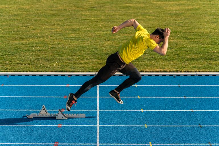 Jeder Augenblick zählt: Ein Hürdensprinter schießt aus dem Startblock – Fotograf Oliver Güth hält die Szene mit einem Zoomobjektiv fest. So kann er die Brennweite schnell wechseln, und spart wertvolle Zeit für den Objektivwechsel.