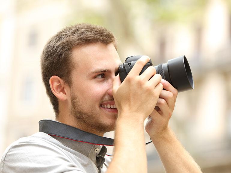 Mann fotografiert mit einer Kamera