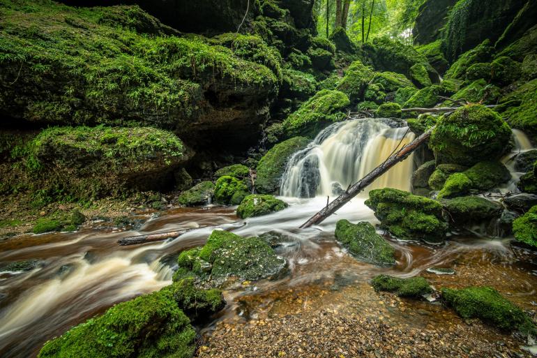 Die Tiefsteinklamm im Salzburger Seenland in Österreich: Um das helle Wasser des Bachlaufs zwischen den im Schatten liegenden Felsen der Schlucht sowie die helle Öffnung zum Wald hin nicht als ausgebrannte Spitzlichter abzubilden, belichtete Martin Gebhardt auf die lichtreichen Stellen des Motivs und nahm dafür tiefe Schatten in Kauf. Dank der Dynamik-Reserven von RAW konnte er diese in der Nachbearbeitung jedoch verlustfrei aufhellen sowie Zeichnung und Details wieder herausarbeiten. Nikon D7500 | 10mm | 1,3 s | f/8 | ISO 100