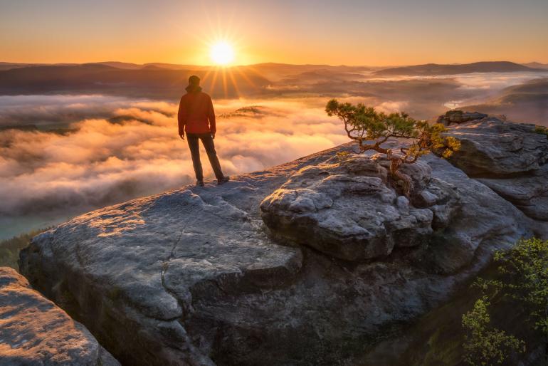 Mystischer Nebel und detailreiche Felsen treffen auf das magische Licht der aufgehenden Sonne: Sie haben eine spektakuläre Naturkulisse – wie diese Aussicht vom Lilienstein im Elbsandsteingebirge in Sachsen auf die Elbe-Region – vor Ihrer Linse? Dann nutzen Sie diese Gelegenheit für eine besonders schöne Erinnerung an Ihren Urlaub und inszenieren Sie sich selbst inmitten der Landschaft. Profi Alexander Lauterbach verrät in den drei Schritten weiter unten, wie es gelingt. Sony Alpha 7R II | 22mm | 1/6 s | f/11 | ISO 50