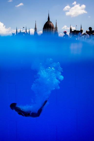 Adriana Jimenez taucht bei den World Championships im High Diving vor dem Budapester Parlament in den Pool. Die Sportlerinnen springen bei dieser Sportart aus 20 Metern Höhe in einen extra dafür angelegtes Gewässer. Die Distanz zwischen den Athletinnen und dem Parlament beträgt etwa 550 Meter Luftlinie. Tiefgang | Nikon 1 AW1 | 11mm | 1/2500 s | f/4 | ISO 250 | 28.07.2017