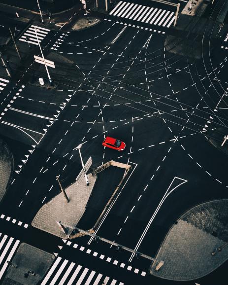 Diese Aufnahme aus der Vogelperspektive fotografierte Langer 2017 in Rotterdam. Beeindruckend ist der starke Kontrast des einsamen, roten Autos inmitten der von Straßenmarkierungen übersäten Kreuzung.