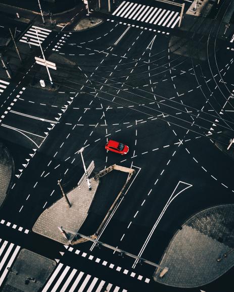 Diese Aufnahme aus der Vogelperspektive fotografierte Langer 2017 in Rotterdam. Beeindruckend ist der starke Kontrast des einsamen, roten Autos inmitten der von Straßenmarkierungen übersäten Kreuzung.