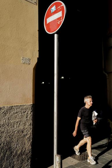 Menschen, die in einen Lichtstreifen hinaustreten, werden vor dem dunklen Hintergrund wie auf einer Bühne angestrahlt. Leica Q2 | Leica Summilux 1:1,7/28 ASPH | 28mm | 1/400 s | f/4,5 | ISO 100