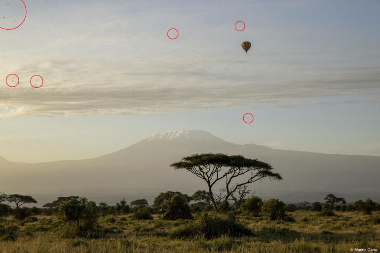 Unschöne Flecken weglöschen: Marinas Bild stellt eine Landschaft im Amboseli-Nationalpark in Kenia mit einem Heißluftballon und Kilimandscharo im Hintergrund dar. Um den Akazienbaum, den Berg und den Ballon scharf abzubilden, wählte sie die Blende f/10, wodurch auch die Staubflecken auf ihrem Kamerasensor sehr deutlich am Himmel zu sehen sind.