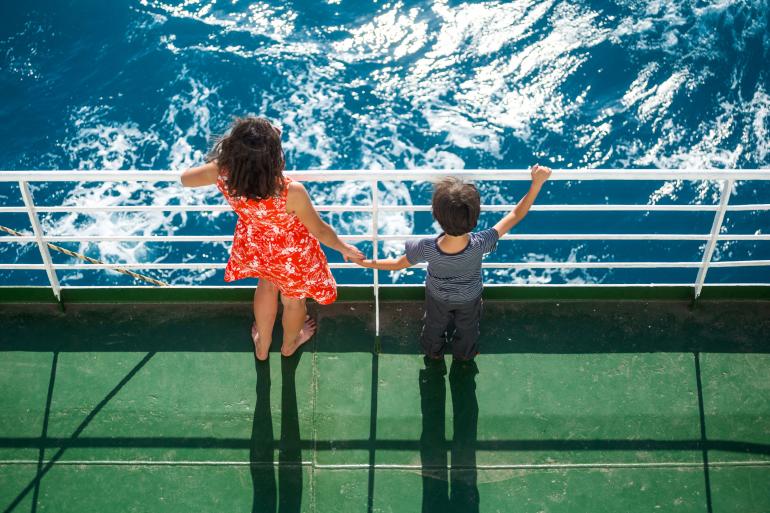 Eine Frau ist mit ihrem Kind auf einem Kreuzfahrtschiff unterwegs.