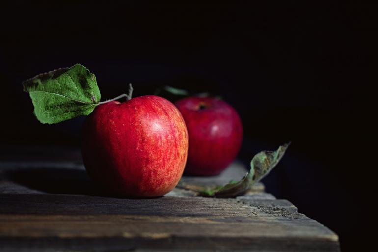 Zwei rote Äpfel auf einem Holztisch