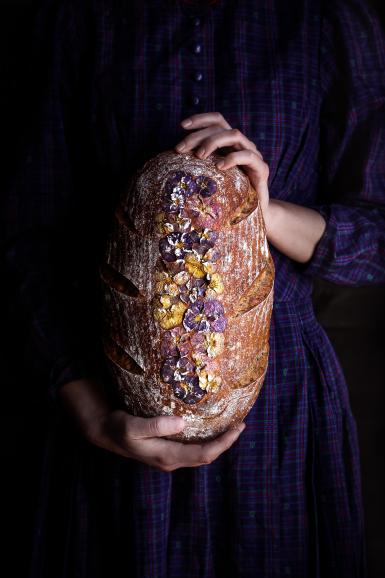 Ich habe seitliches, natürliches Licht verwendet und es in meinem Esszimmer fotografiert. Die Komplementärfarben Gelb und Violett harmonieren in diesem Bild gut mit der Textur des Brotes und dem Kleid.“