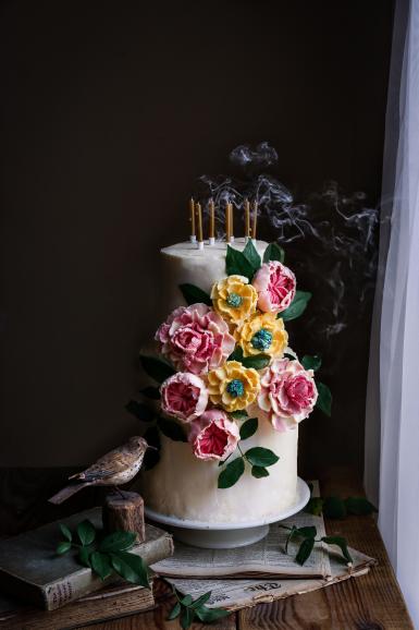 Ein Geburtstagskuchen, den Barbora Baretic für ihre Tochter gebacken hat. Die Blumen bestehen aus weißer Schokoladenganache – Blütenblatt für Blütenblatt geformt. Der Rauch der Kerzen verleiht dem Bild eine schöne Dynamik.