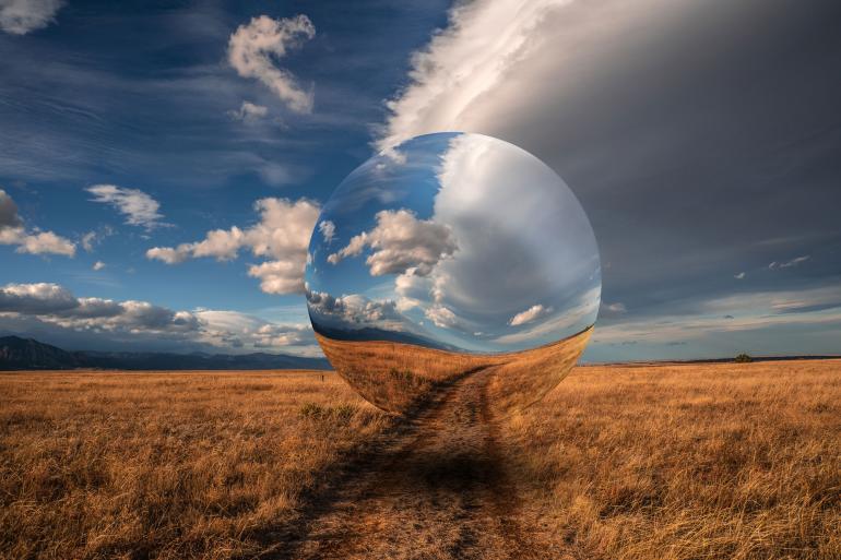 Eine surreale Illusion inmitten der Natur: Eine perfekte Glaskugel verzerrt die Landschaft und lässt Realität und Fantasie nahtlos ineinander übergehen.