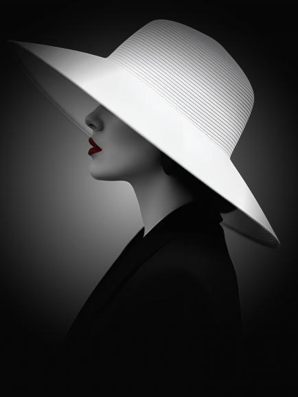 Eine elegante Frau trägt einen großen weißen Hut, der ihr Gesicht teilweise verdeckt. Das Bild ist fast vollständig in Schwarz-Weiß gehalten, nur die roten Lippen setzen einen starken farblichen Akzent.